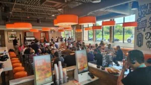 Visita a Buona, restaurante de comida tradicional de Chicago, mostrando pessoas comendo e pontos de autoatendimento.