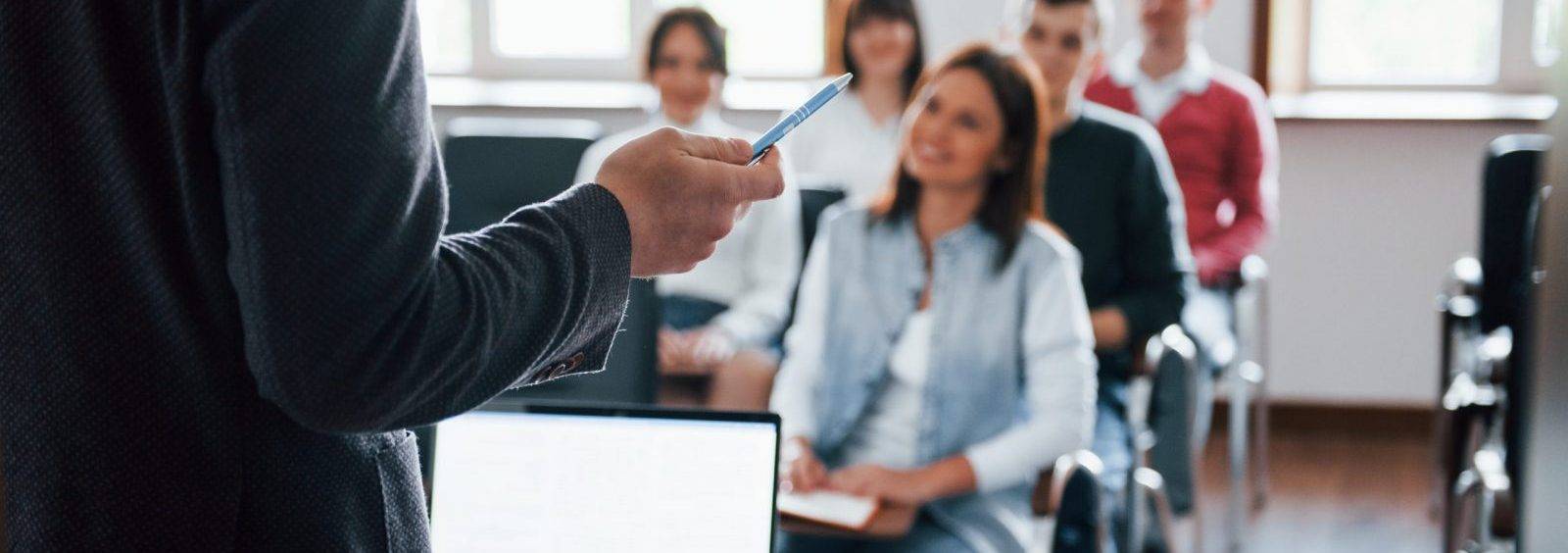 Everyone Is Smiling And Listens Group Of People At Business Conference In Modern Classroom At Daytime 1 Scaled E1666117530891